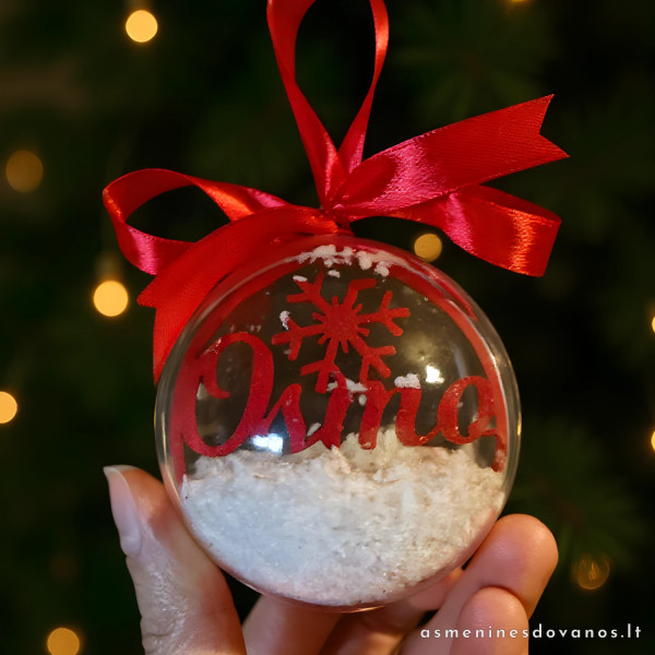 Kalėdinis žaisliukas - burbulas su vardu viduje ir rausvu kaspinu.