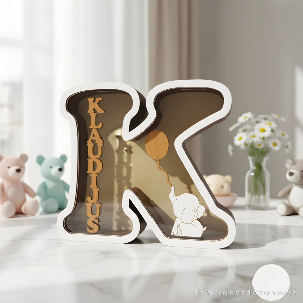 Taupyklė  raidė. Taupyklė su pjaustytu vardu ir dekoracija drambliu.